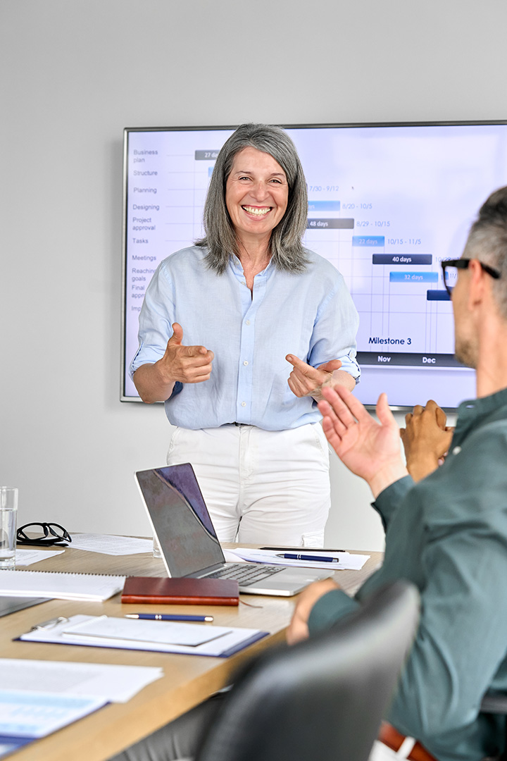 Happy woman in meeting with presentation in background